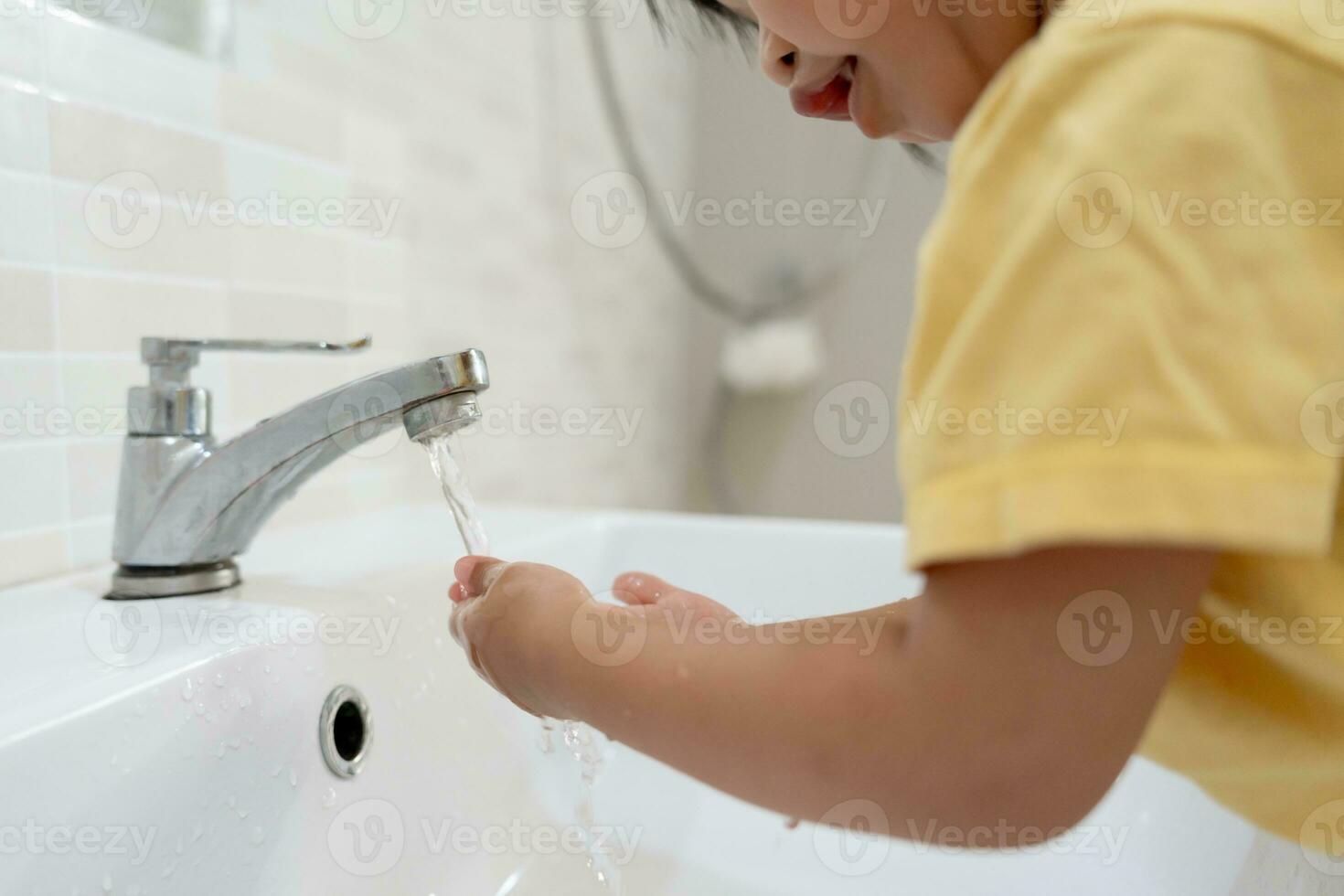 pequeño niño manos lavar con jabón burbujas y enjuague con limpiar agua a evitar y detener el untado de gérmenes después espalda a hogar, virus o COVID-19. bueno salud y bueno personal higiene, virus, bacterias foto