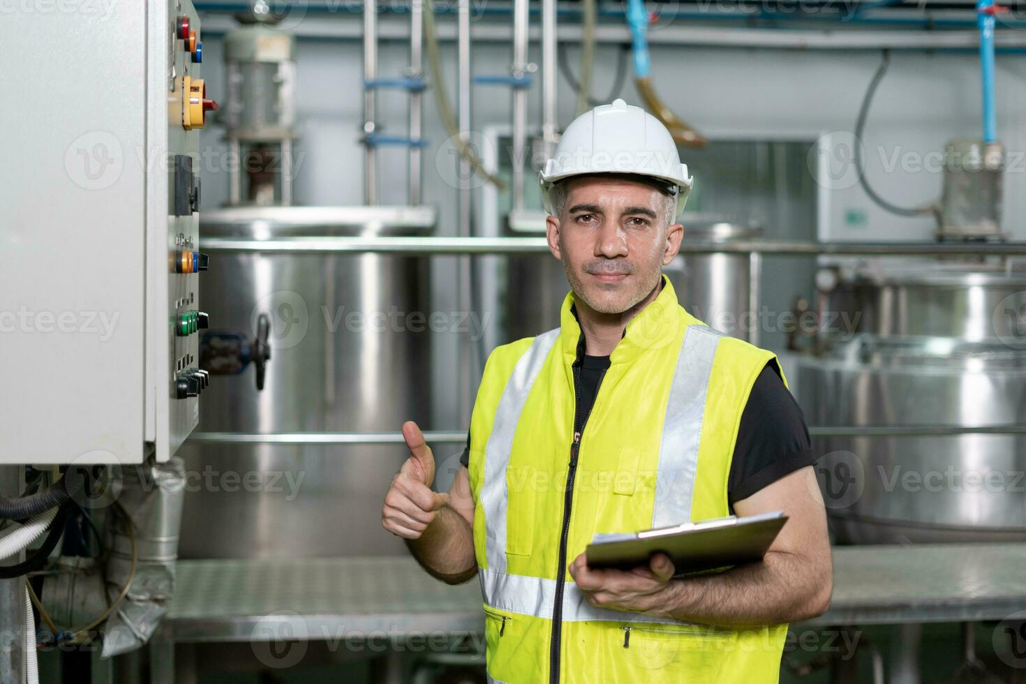 portrait Engineers or factory managers wearing safety helmet inspect the machines in the production line. The inspector opened the machine to test the system to meet the standard. machine maintenance photo