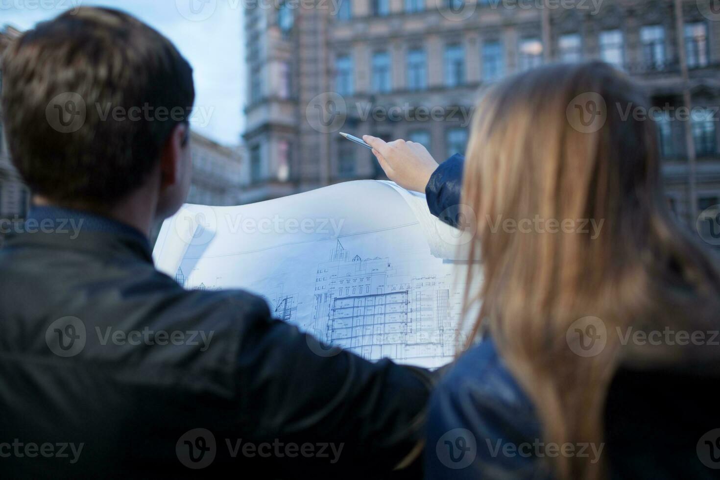 Man and woman holding blueprint photo