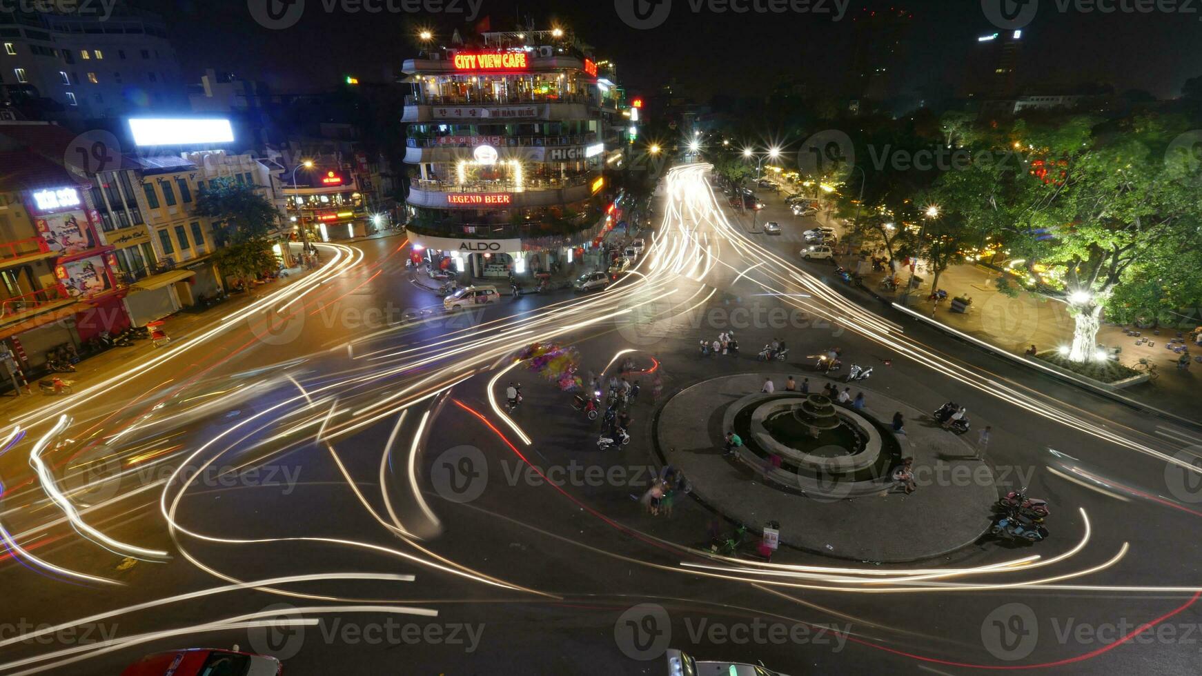 City square with traffic in motion at night. Hanoi, Vietnam photo