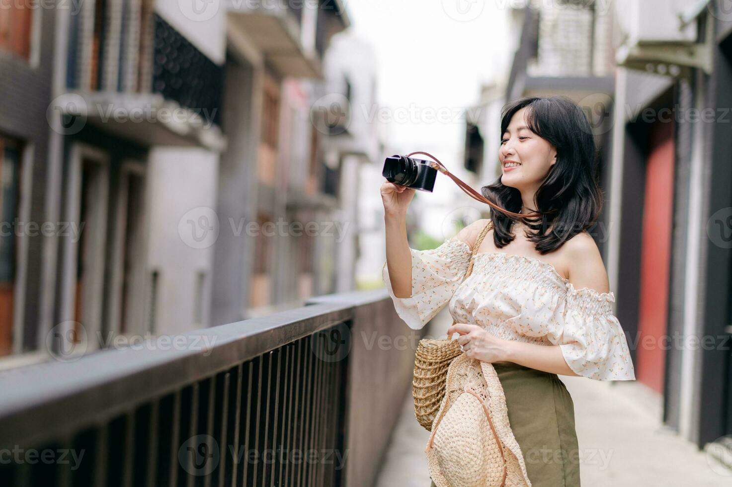 Happy youth asian woman with camera travels street city trip on leisure weekend. Young hipster female tourist sightseeing summer urban Bangkok destination. Asia summer tourism concept. photo