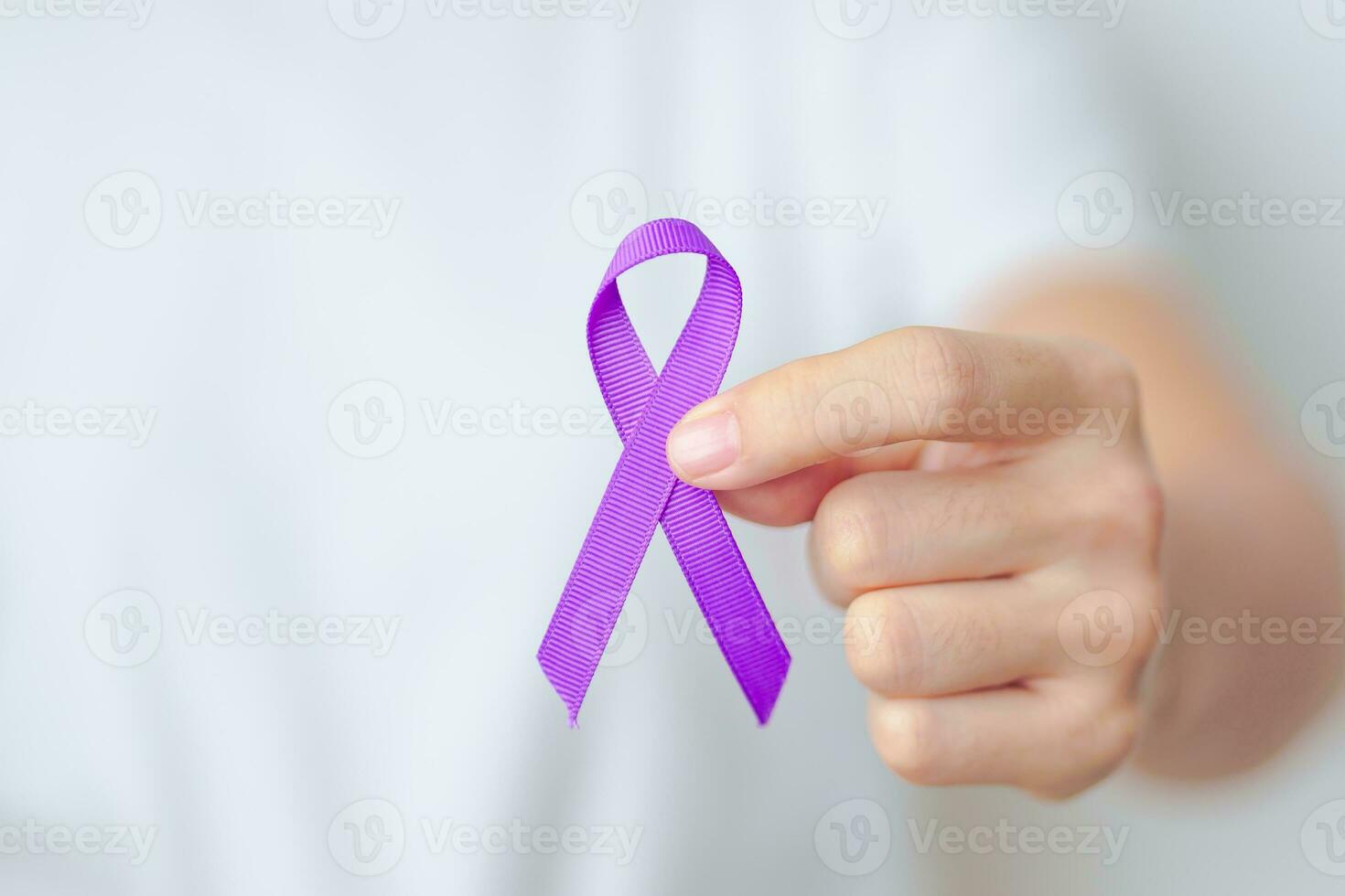 Woman holding purple Ribbon for Violence, Pancreatic, Esophageal, Testicular cancer, Alzheimer, epilepsy, lupus, Sarcoidosis and Fibromyalgia. Awareness month and World cancer day concept photo