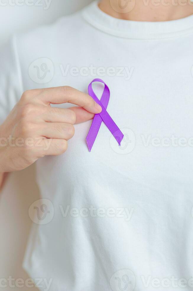 Woman holding purple Ribbon for Violence, Pancreatic, Esophageal, Testicular cancer, Alzheimer, epilepsy, lupus, Sarcoidosis and Fibromyalgia. Awareness month and World cancer day concept photo