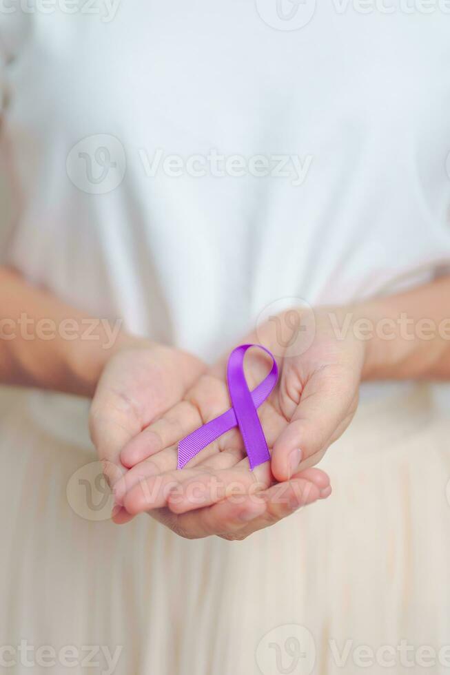 Woman holding purple Ribbon for Violence, Pancreatic, Esophageal, Testicular cancer, Alzheimer, epilepsy, lupus, Sarcoidosis and Fibromyalgia. Awareness month and World cancer day concept photo