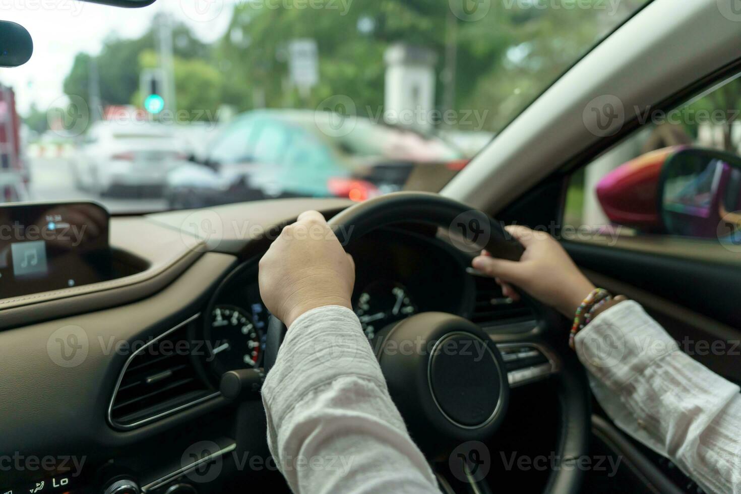 mujer conducción coche. niña sensación contento a conducir participación direccion rueda y mirando en la carretera foto