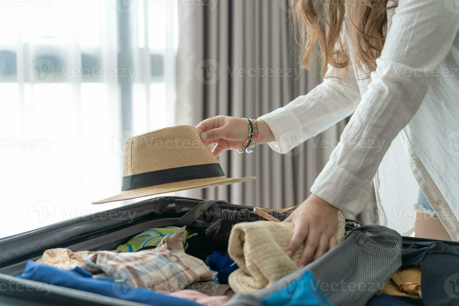 Woman packing suitcase on bed for a new journey packing list for travel planning preparing vacation Book Now Traveling Transportation photo