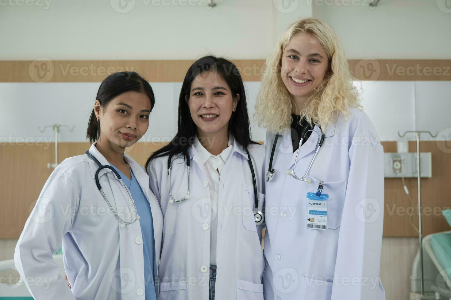 Professional medical staff team, three white uniformed female doctors looking at camera, cheerful and smiling, happy physical work occupation in hospital clinic. photo