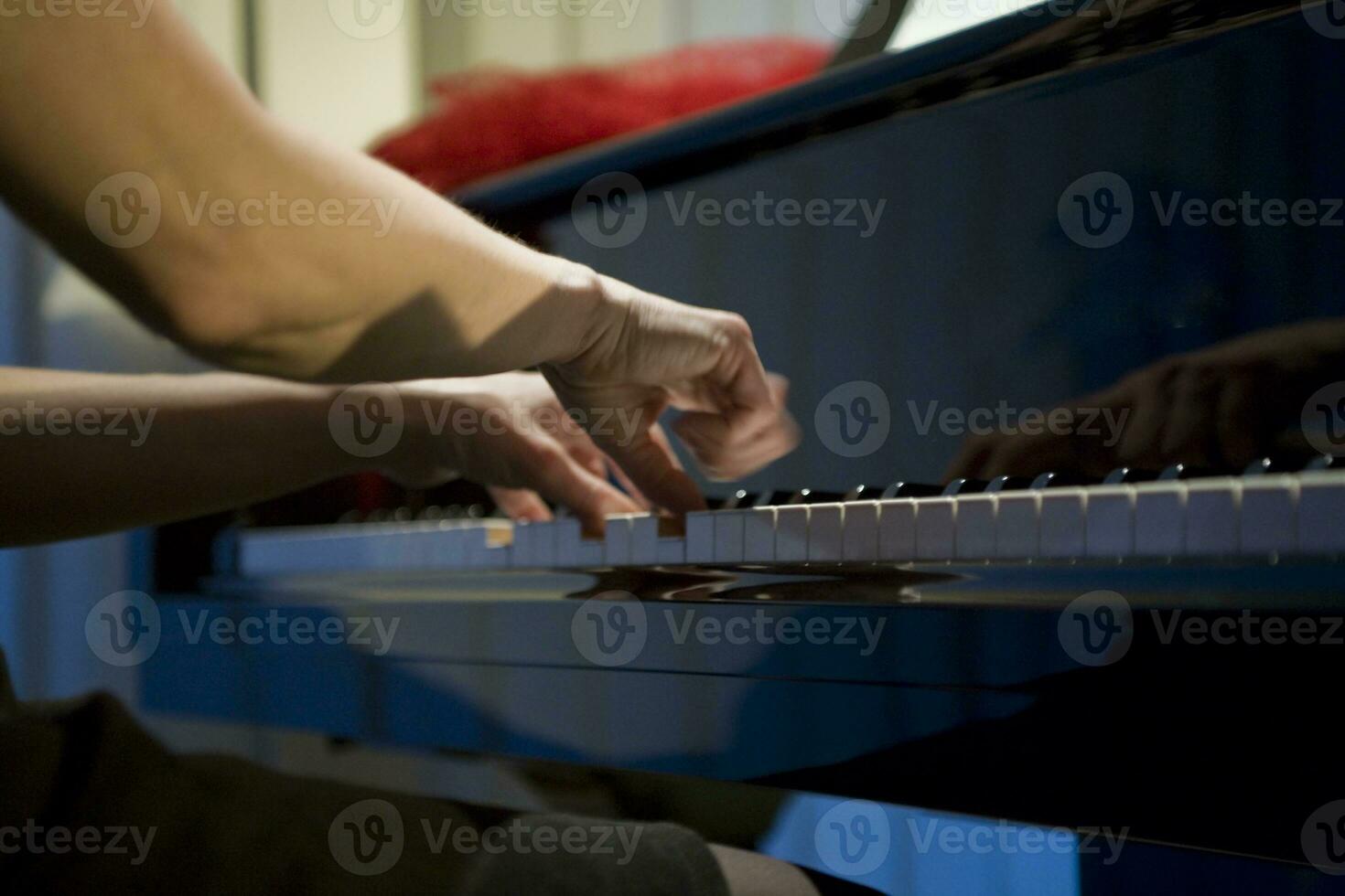 close-up on the hands of a woman playing the piano with music keys photo