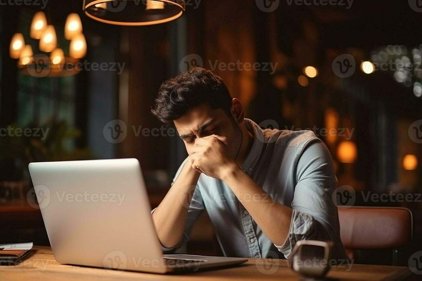 Stressed business man sitting at office workplace. Tired and overworked student man. Young exhausted men in stress working on laptop computer. AI Generated photo