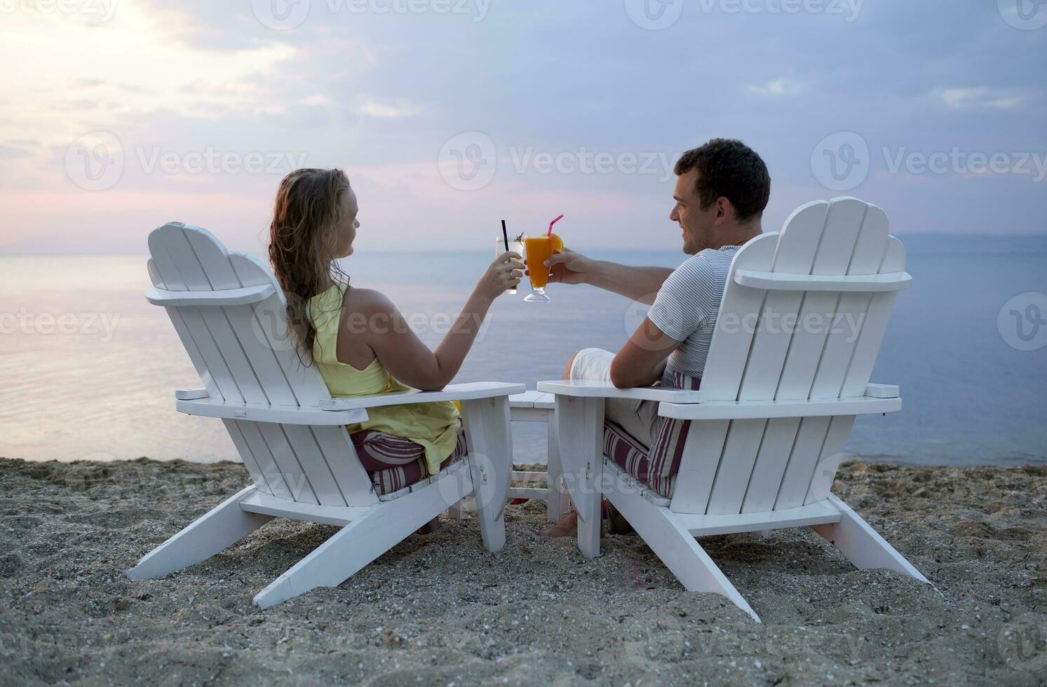 pareja romántica brindando por la puesta de sol foto