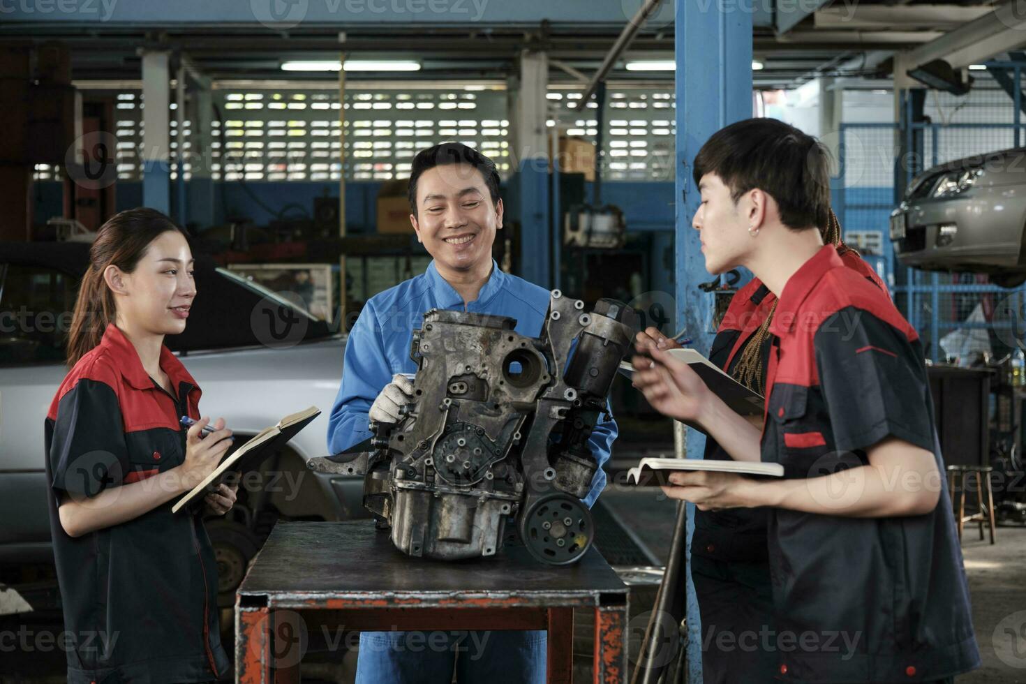 Specialist lecture, a male supervisor engineer train and describe automotive engines with mechanic worker staff teams for repair work at car service garage and maintenance jobs in automobile industry. photo