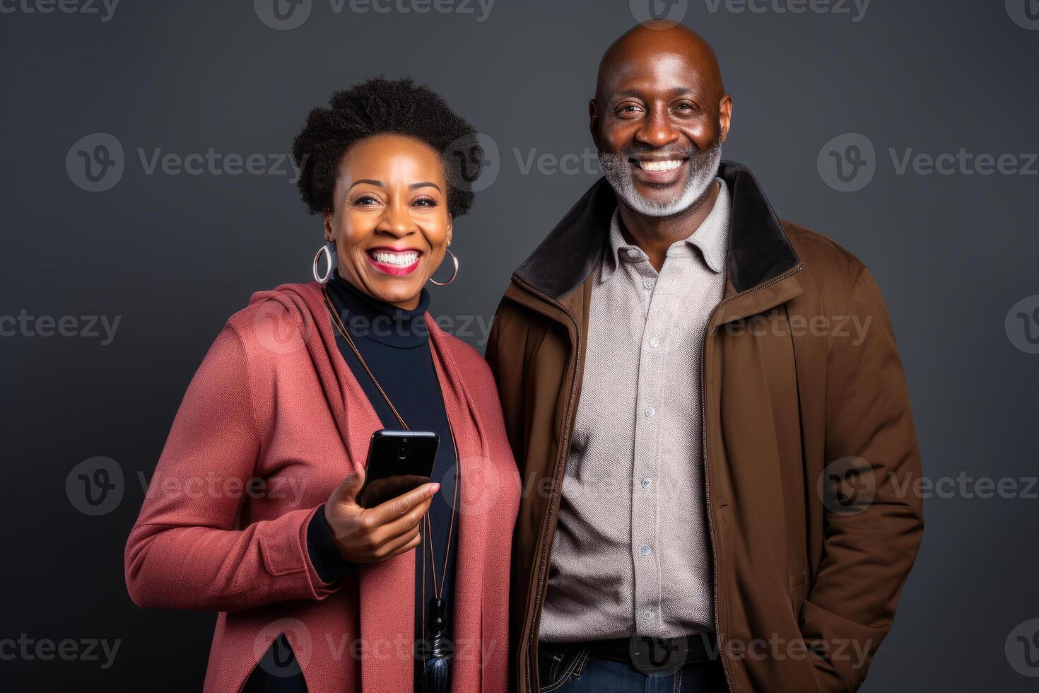 attractive mature black woman and black man with phone on studio color background. photo