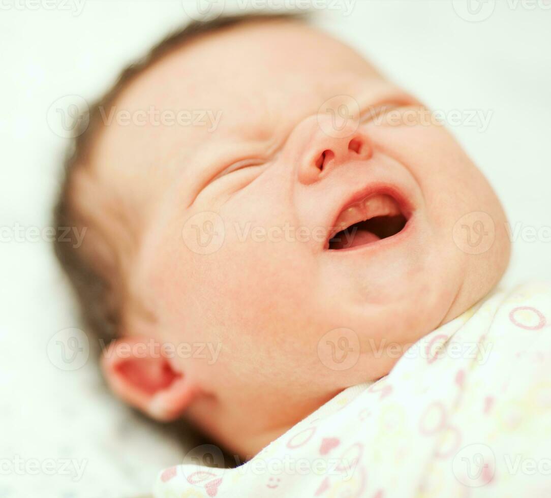 Portrait of crying newborn baby photo