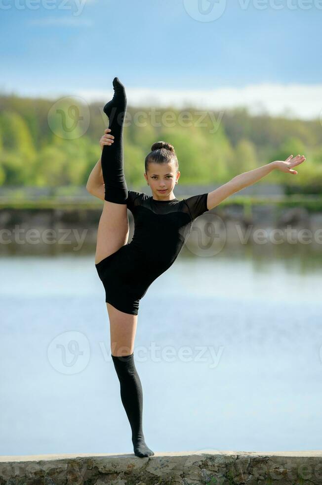 Rhythmic gymnast doing vertical leg-split photo