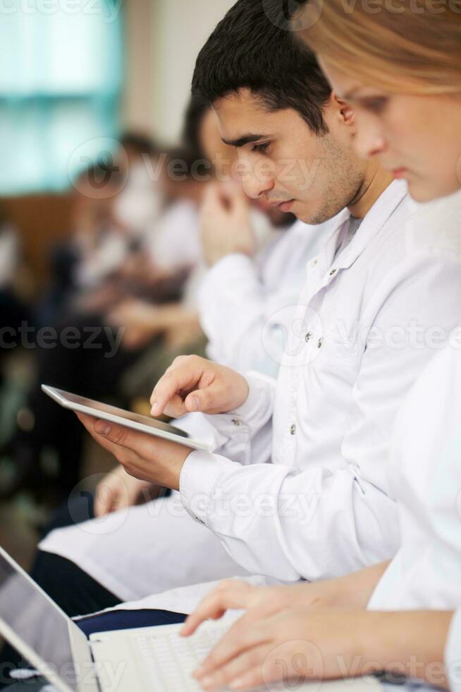 médico estudiantes con moderno dispositivos en el conferencia foto