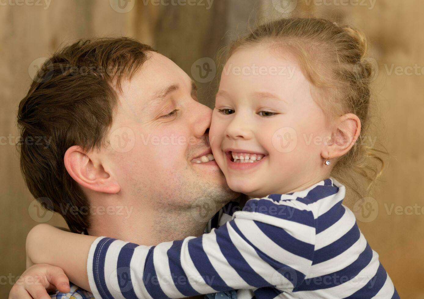 Happy father kissing little daughter photo