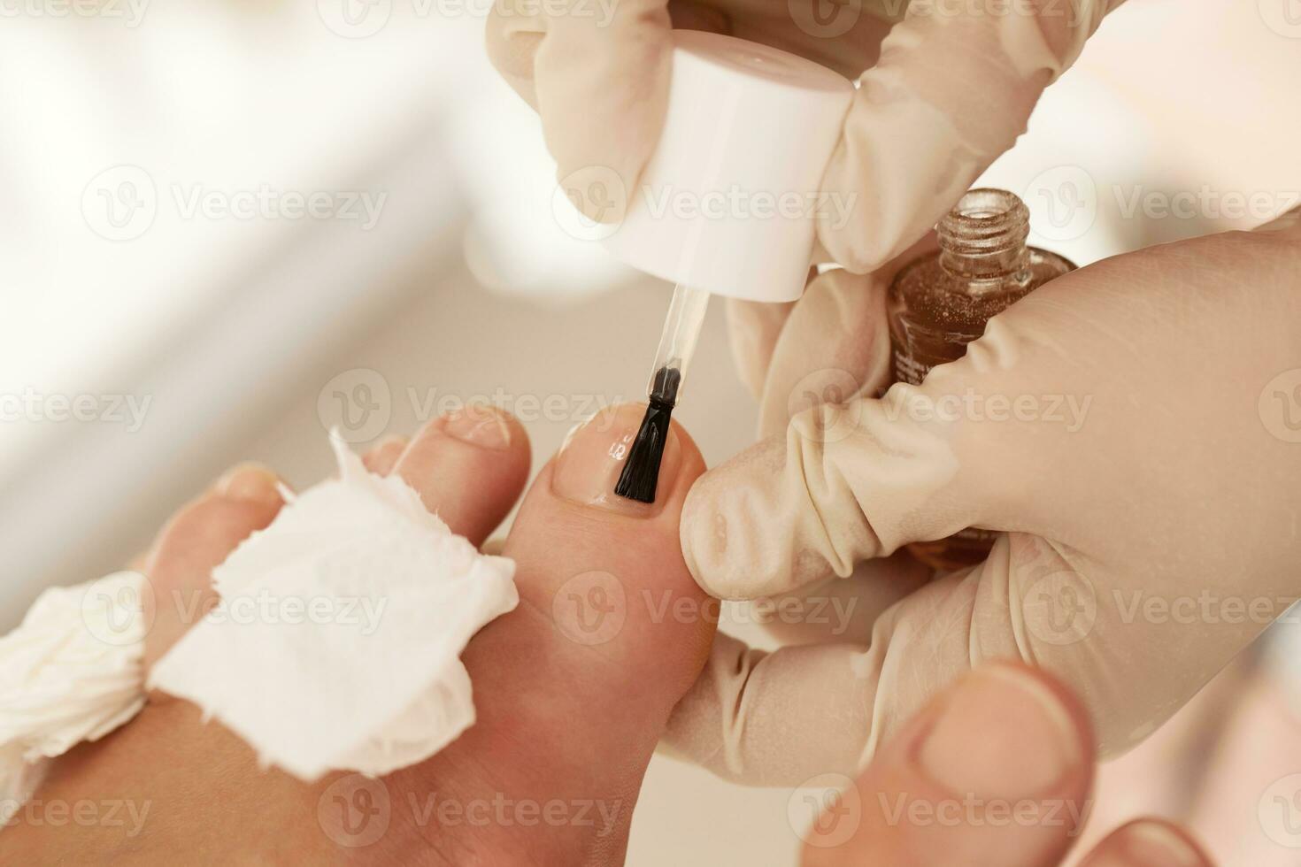 aplicar esmalte de uñas durante la pedicura en el spa de belleza foto