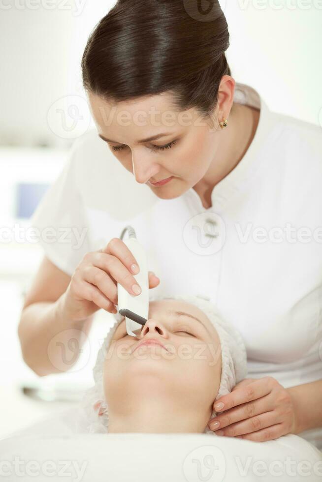 Ultrasonic facial cleaning at beauty treatment salon photo