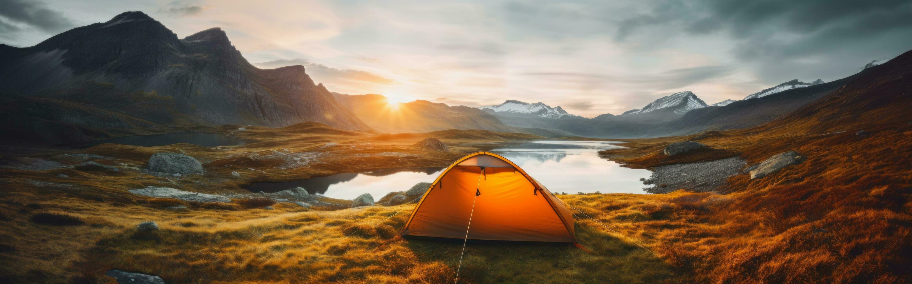 Lonely glowing orange tent on mountains with lagoon on morning light, by AI Generative. photo