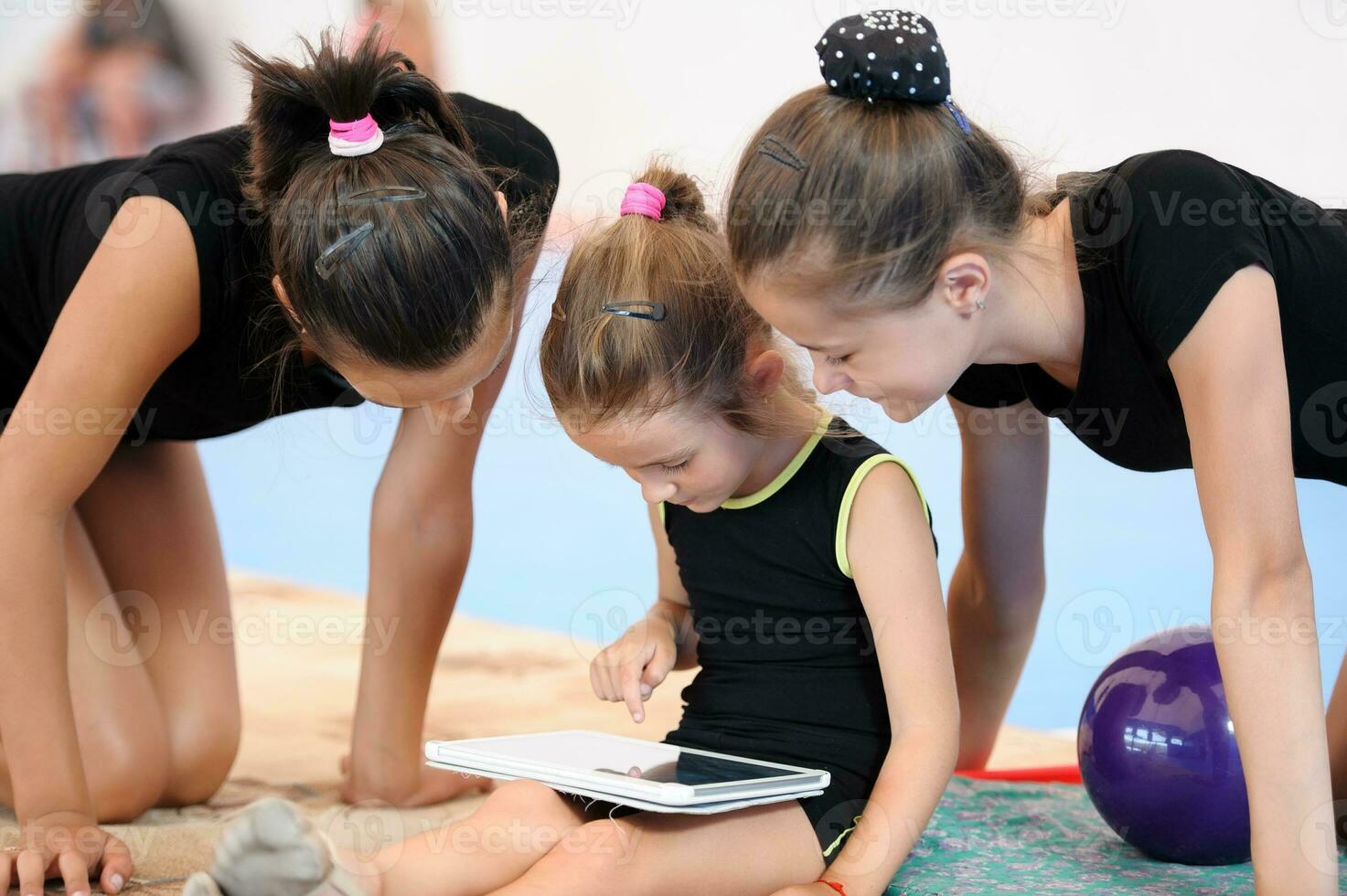 Tres gimnasta muchachas con tableta computadora foto