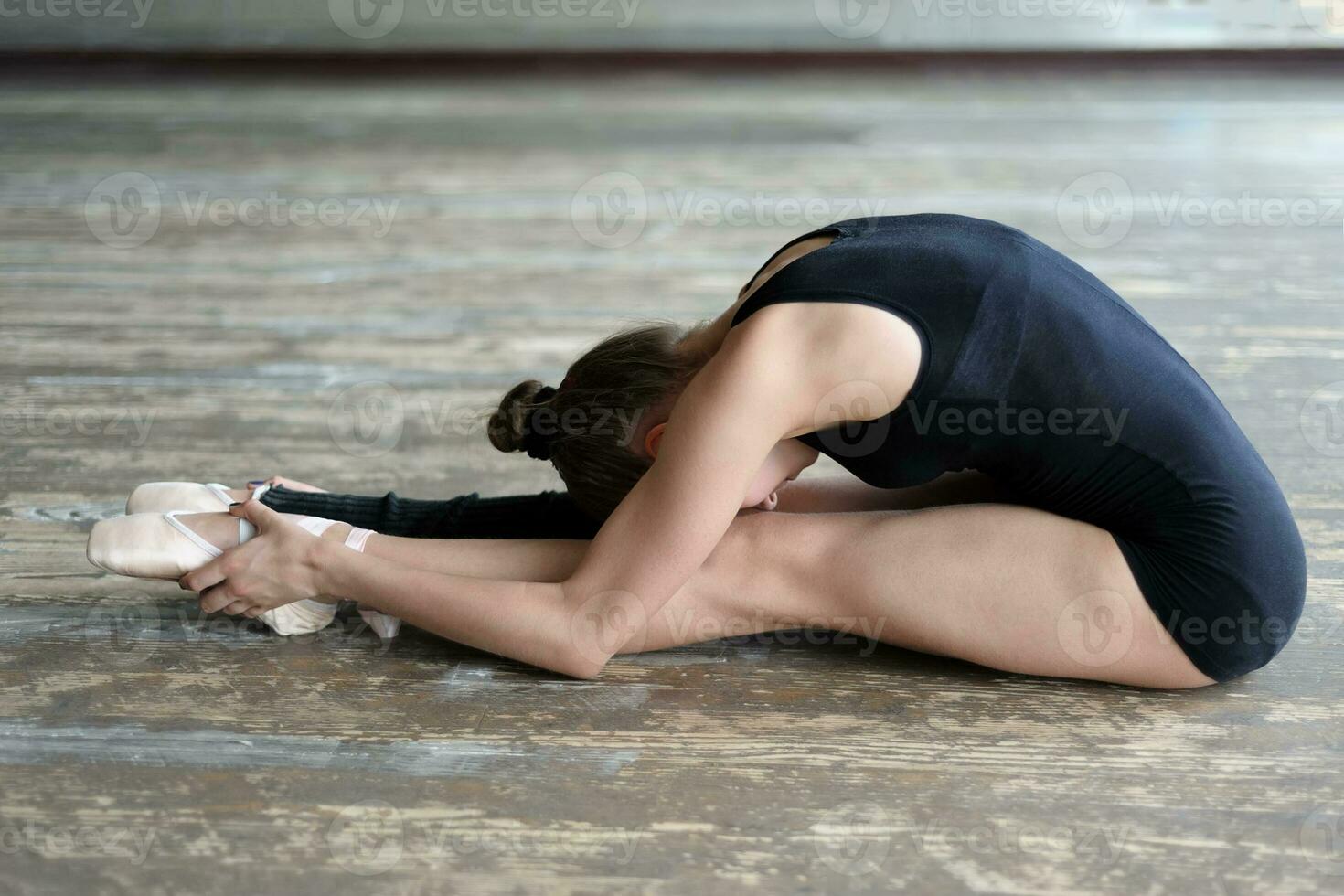 Ballet dancer stretching out sitting on the floor photo