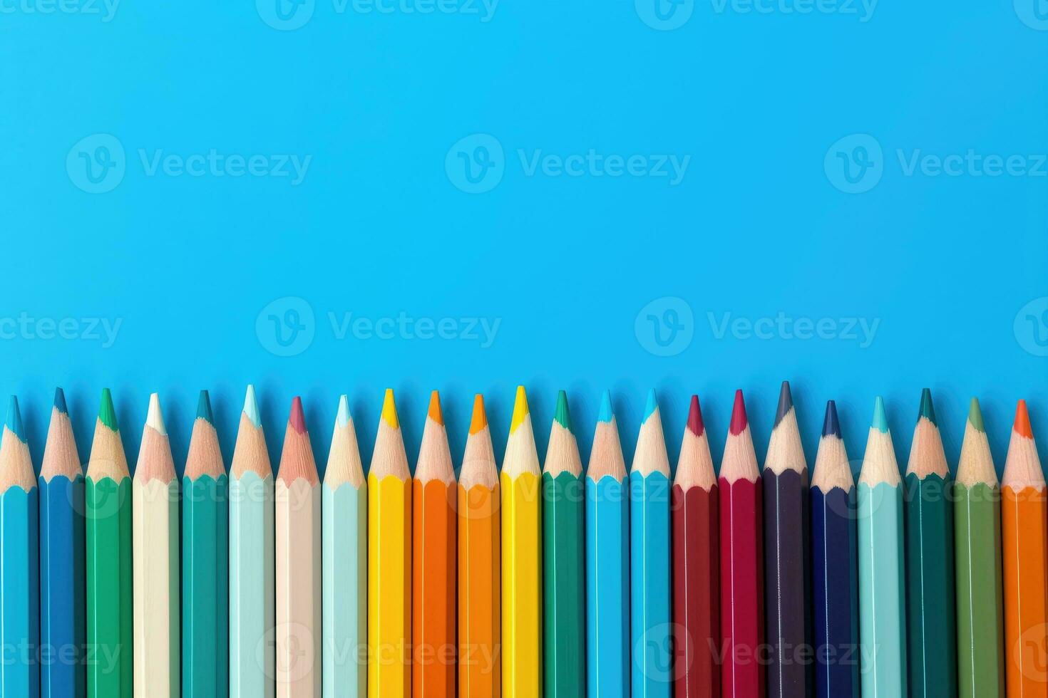 Colored pencils on blue background photo