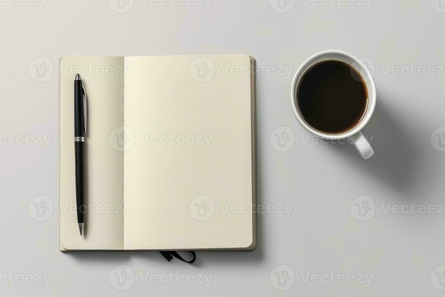 Open notebook with a pen and a cup of coffee on a table photo