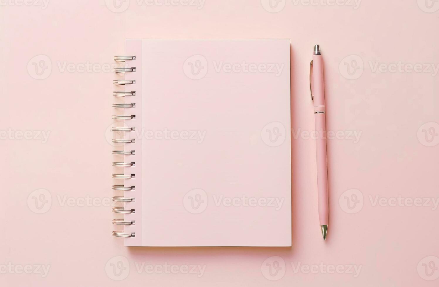 Notepad with blank pages and pen on a pink background. photo