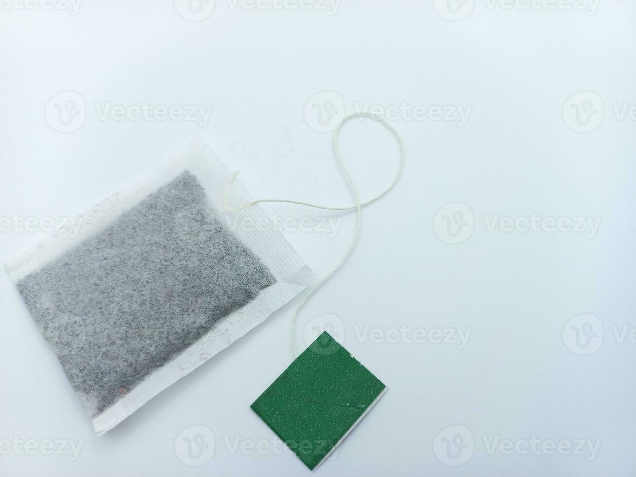 Tea Bag With Green Tag Isolated On White Background. Corner Position With Negative Space photo