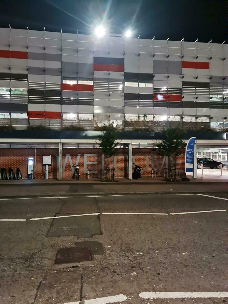 Low Angle View of Illuminated Road and Car Park Building Opposite of Luton and Dunstable Hospital at Luton City of England UK During night of Sep 3rd, 2023. photo