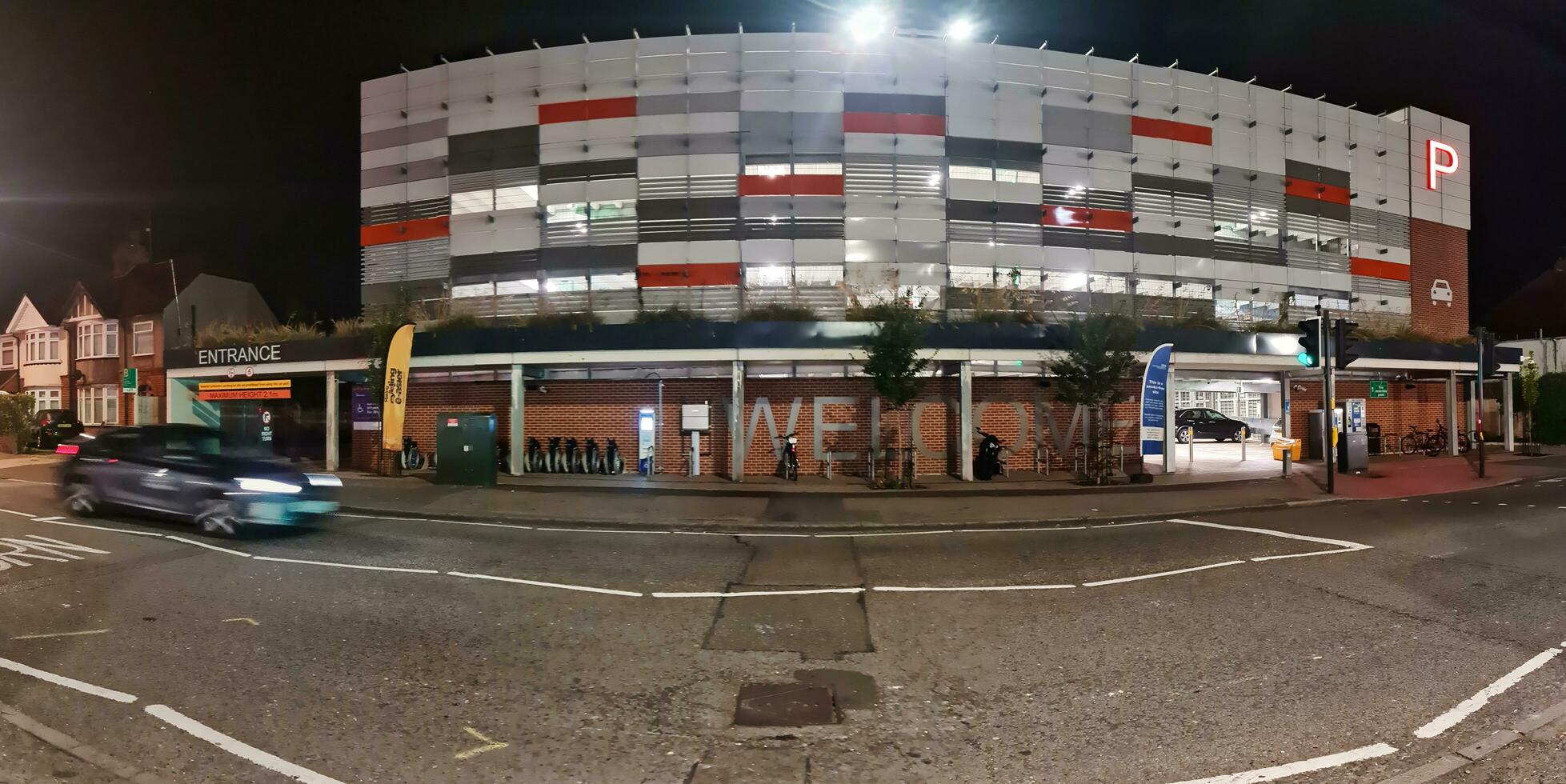 Low Angle View of Illuminated Road and Car Park Building Opposite of Luton and Dunstable Hospital at Luton City of England UK During night of Sep 3rd, 2023. photo