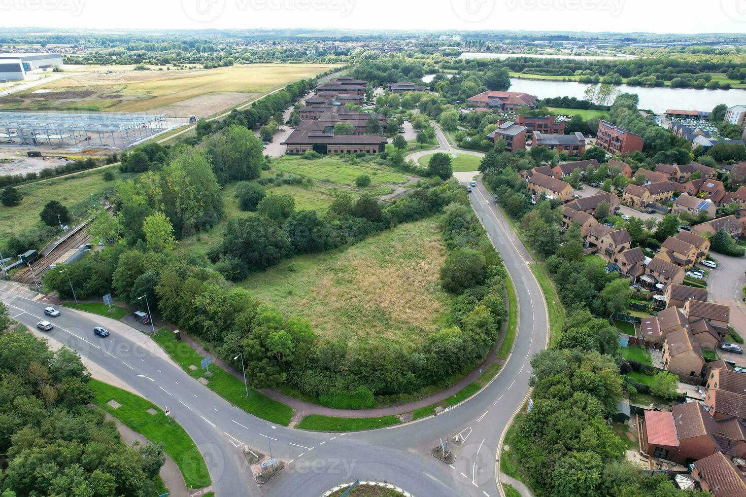 High Angle Footage of British Road and Traffic at Caldecotte Lake of Milton Keynes City of England Great Britain, Beautiful View Captured on August 21st, 2023 with Drone's Camera During Sunny Day photo
