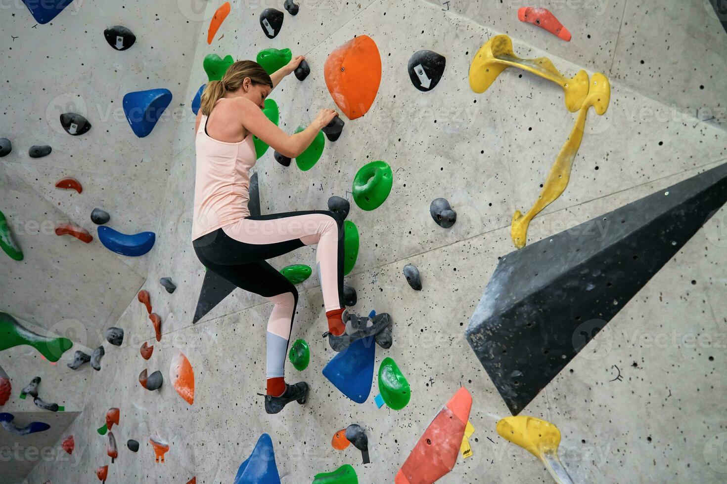 Woman training at bouldering gym. Active recreation, sports exercises photo