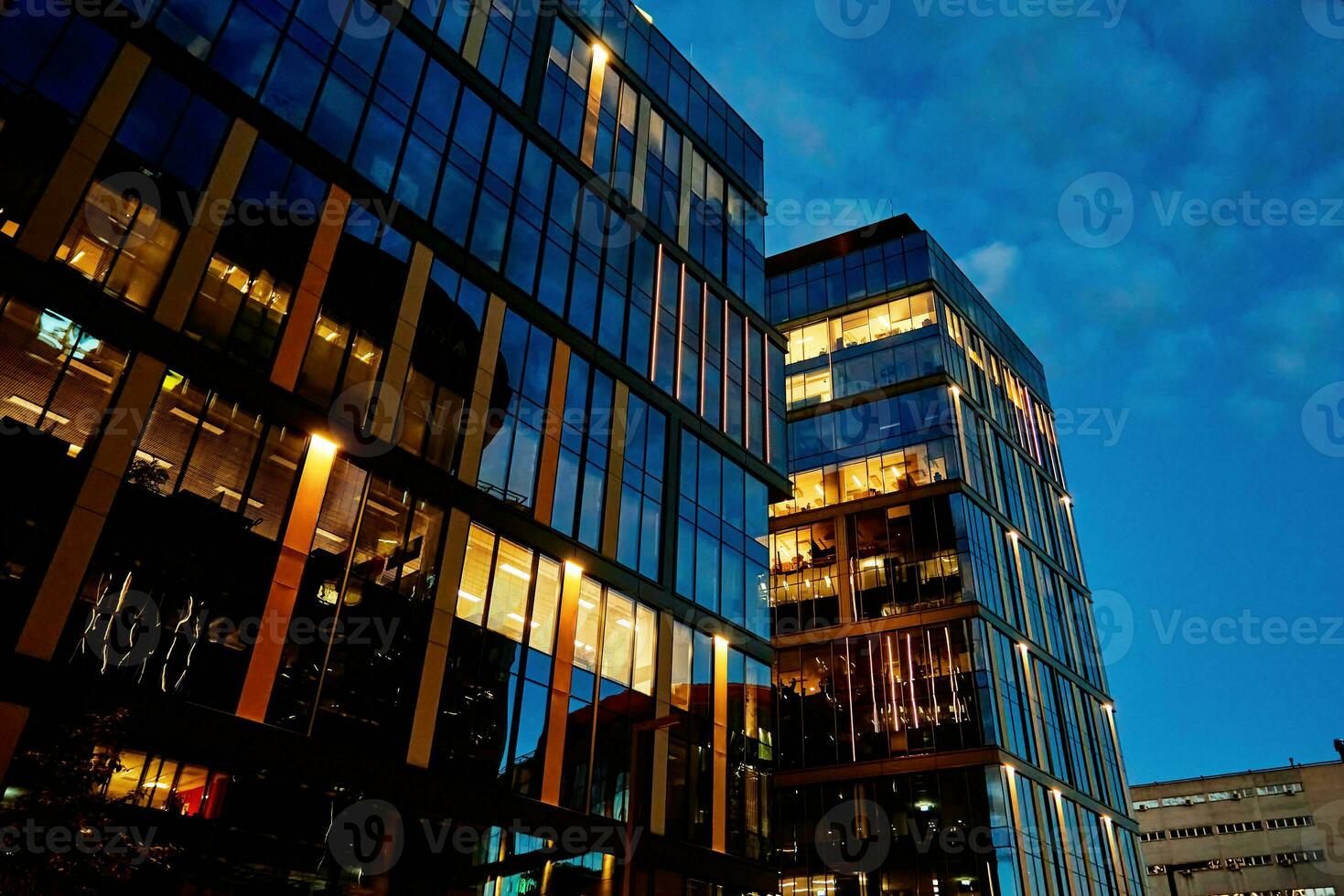 High rise office building with illuminated windows at night photo