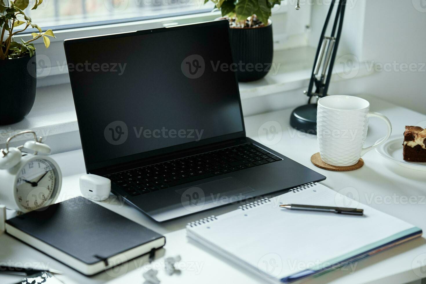 Opened laptop on the table near window. Home office and remote work photo