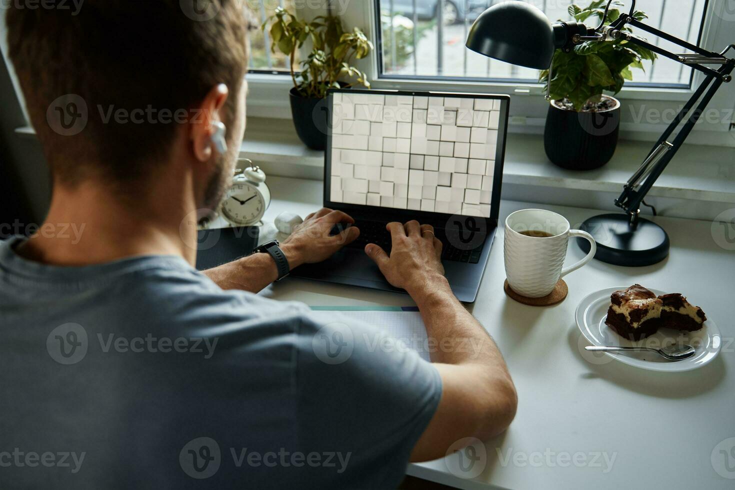 Man sitting at table by the window and using laptop photo