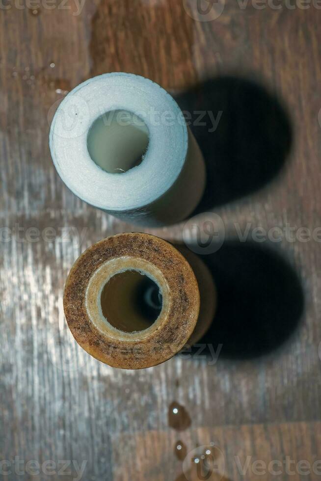 Used water filters with traces of dirt, clay and impurities and clean filters, prepared for replacement. Replacing multi-stage water filter cartridges. photo