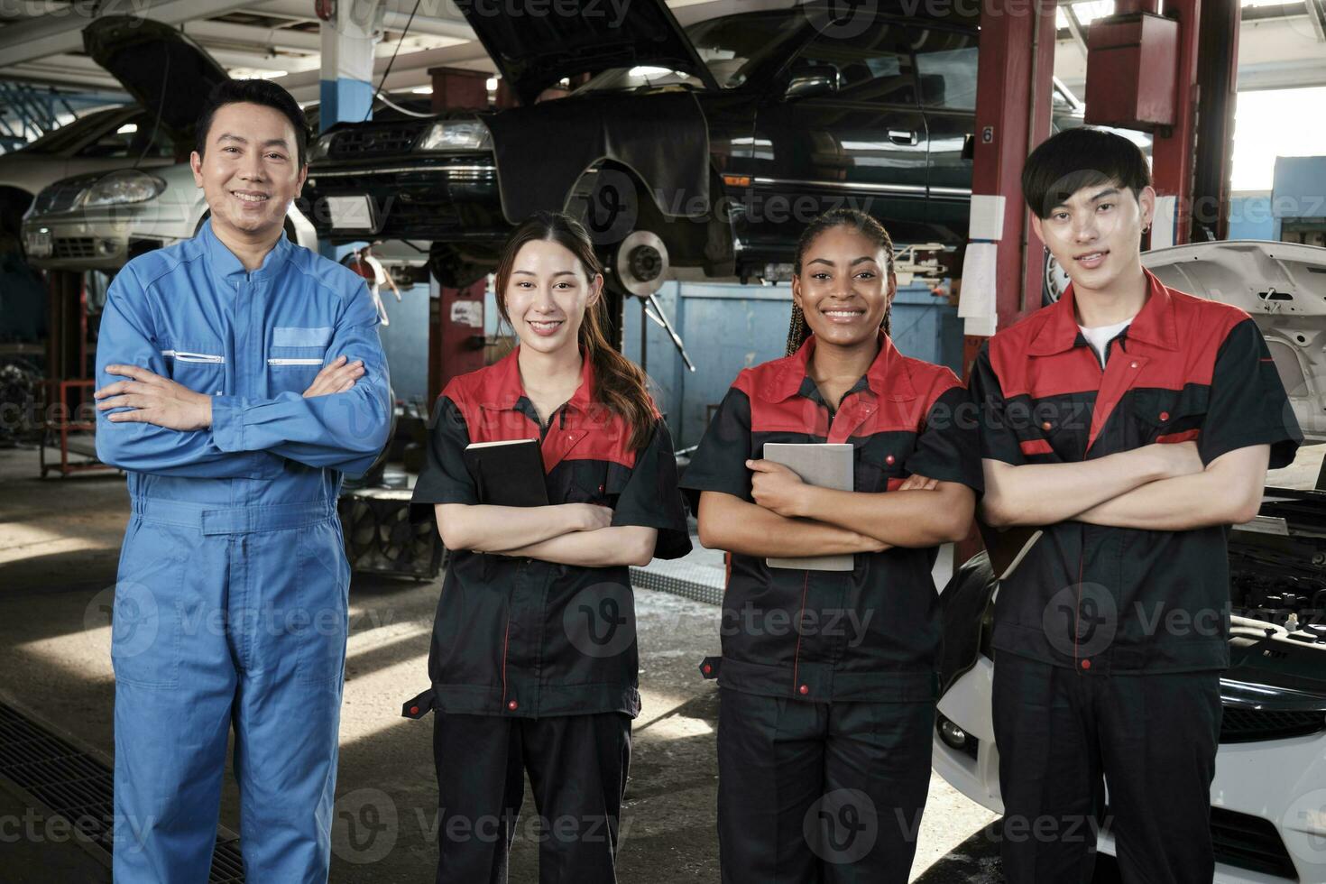 retrato de multirracial profesional mecánico equipo brazos cruzado y Mira a cámara, trabajo a coche Servicio cochera, contento mantenimiento trabajos, cheque y reparar ocupación en automotor industria negocio. foto