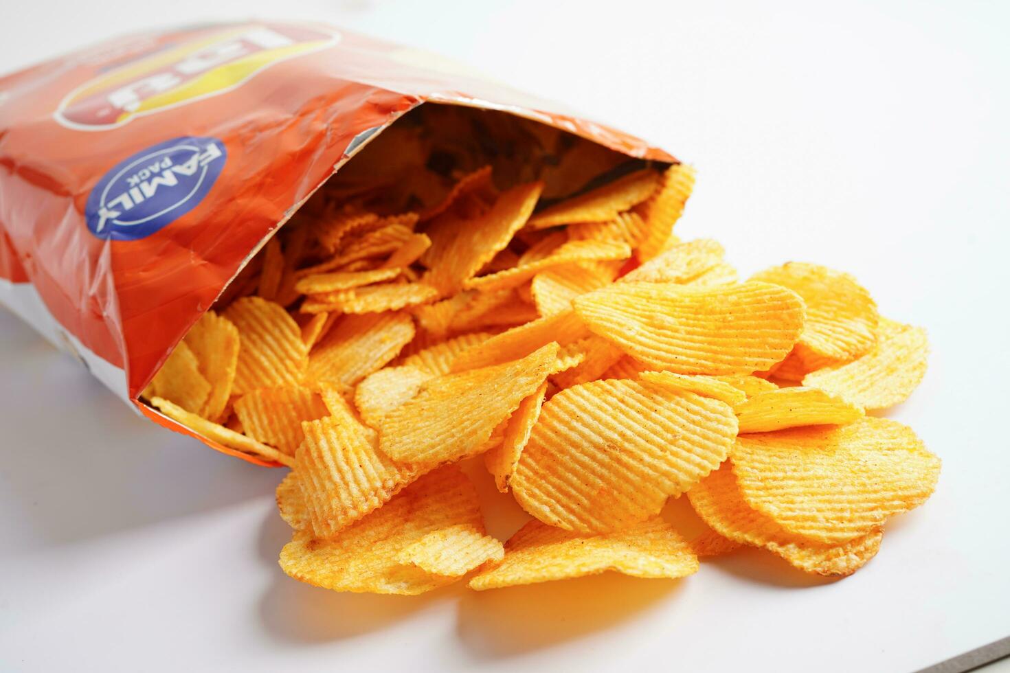 Bangkok, Thailand - May 15, 2022 Potato chips in open bag, delicious BBQ seasoning spicy for crips, thin slice deep fried snack fast food. photo