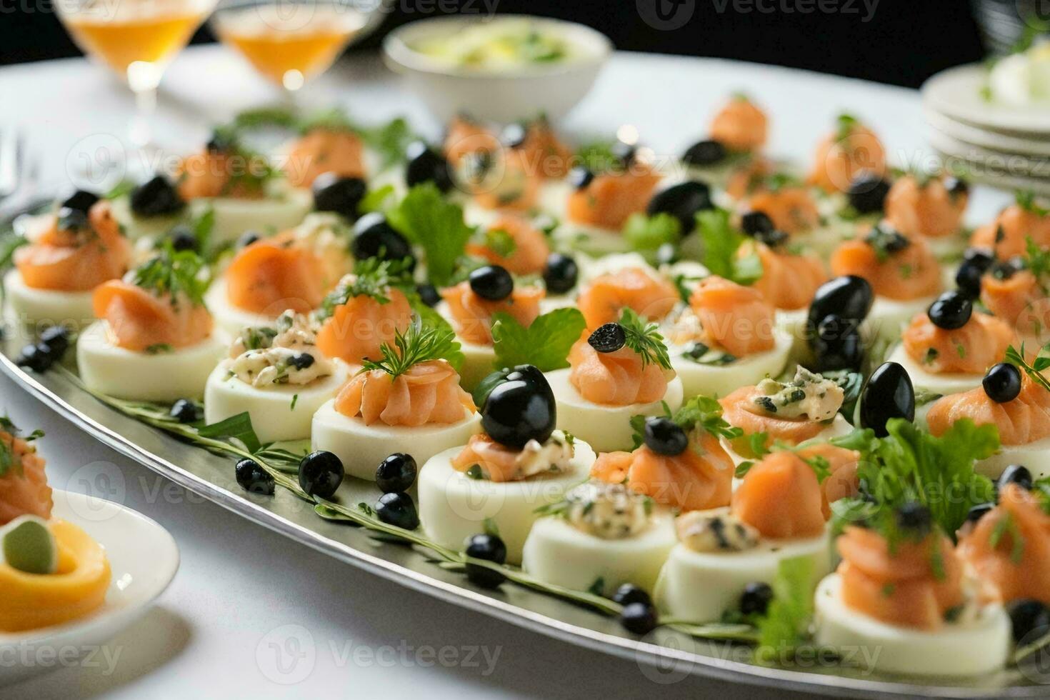 a stunning platter of appetizers on a silver platter, placed on a pristine white tablecloth. photo