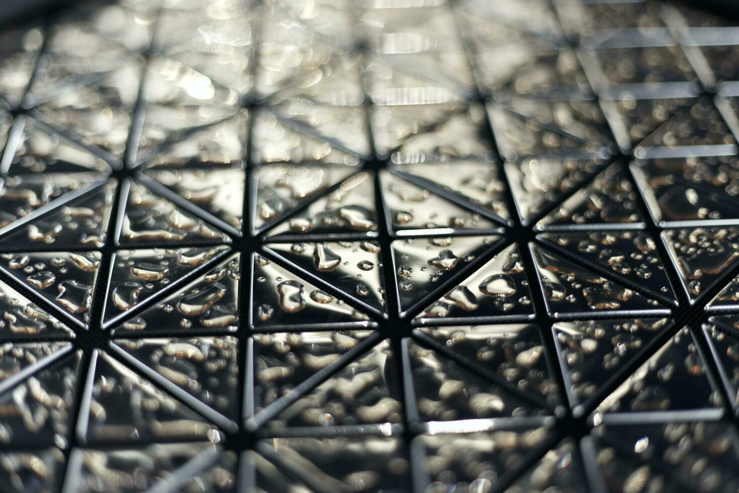 close up of a glass mirror tile with water marks background photo