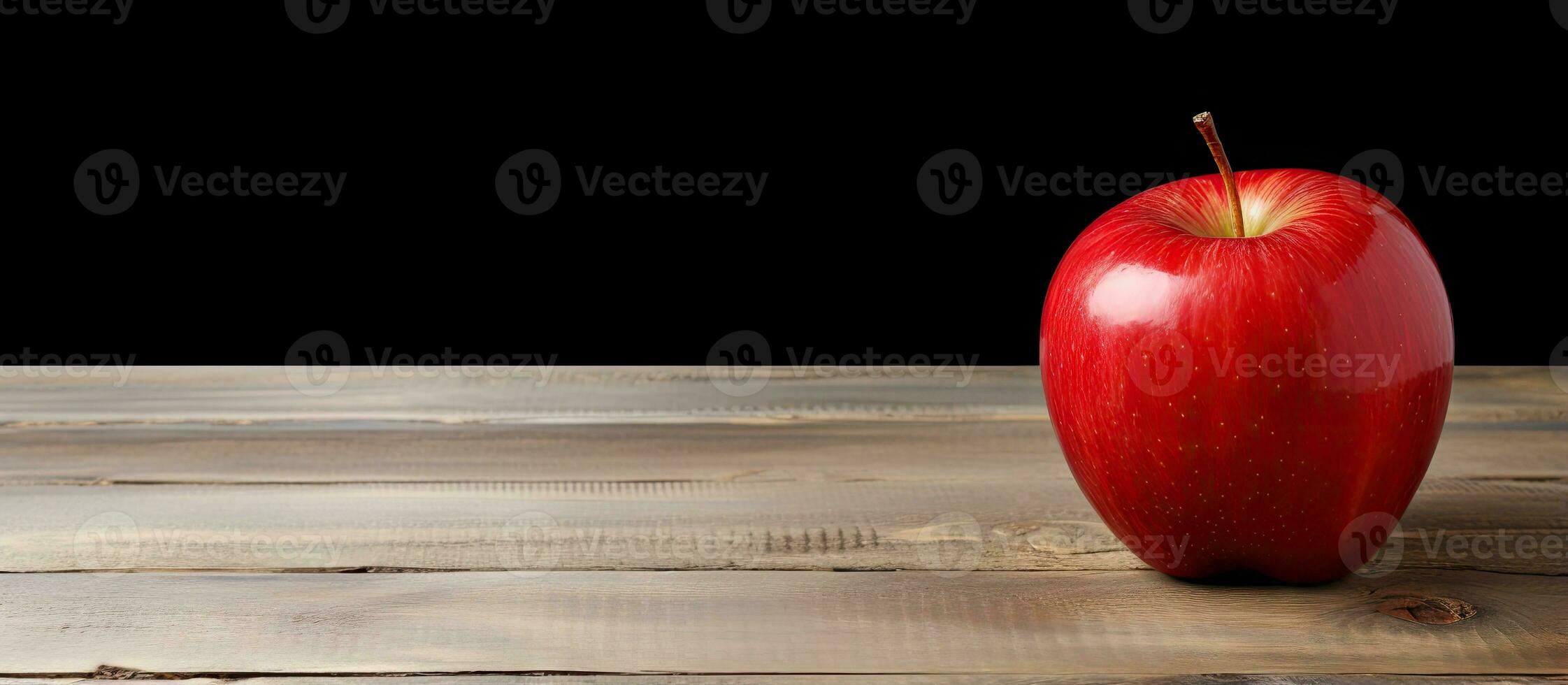 Wooden table with artificial red apple photo