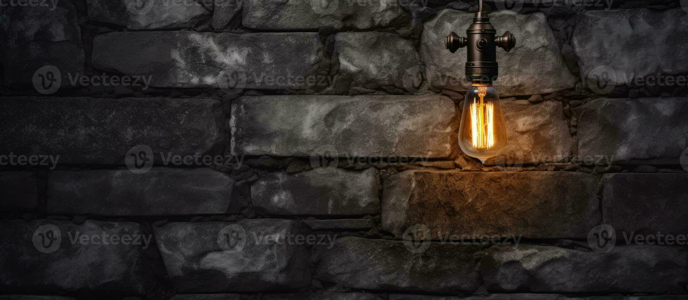 Industrial wall lamp against dark stone wall photo