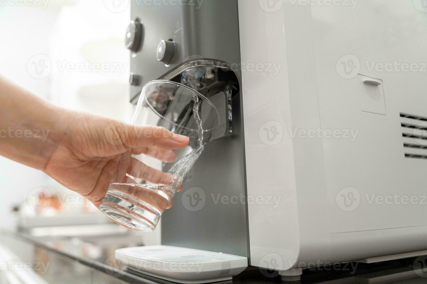 de cerca mano de mujer relleno vaso con agua desde enfriador , Bebiendo agua máquina foto