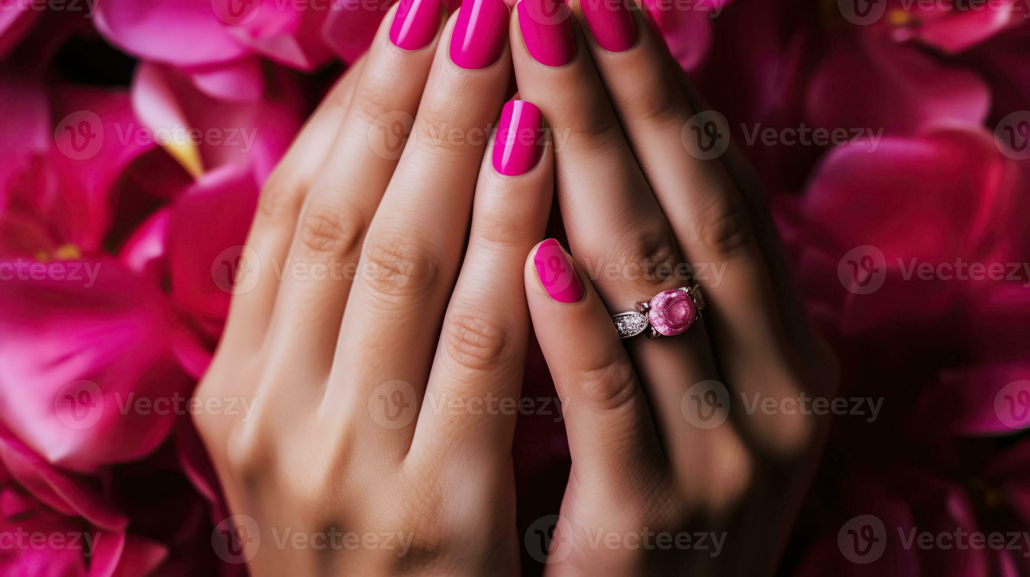 Womans hands knuckles up with wedding ring and bright pink nail polish