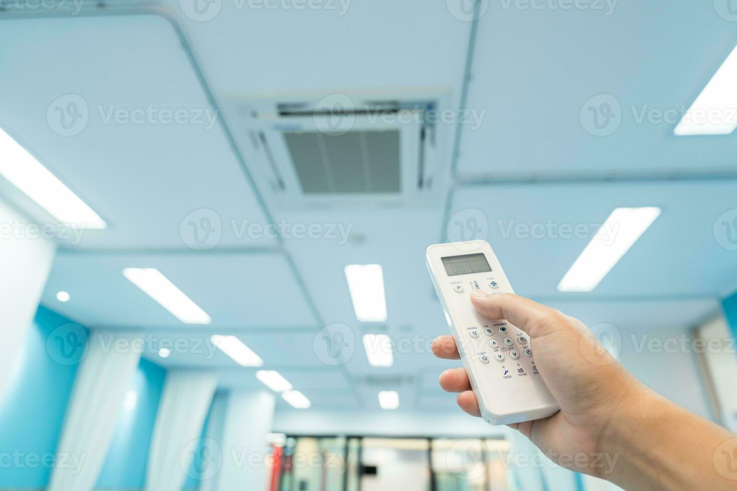 hand holding built-in large air conditioner remote control in the hospital photo