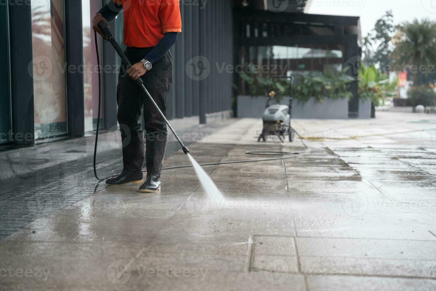 cleaning staff hoses a portable car for washing the concrete floor with high-pressure water jets. photo