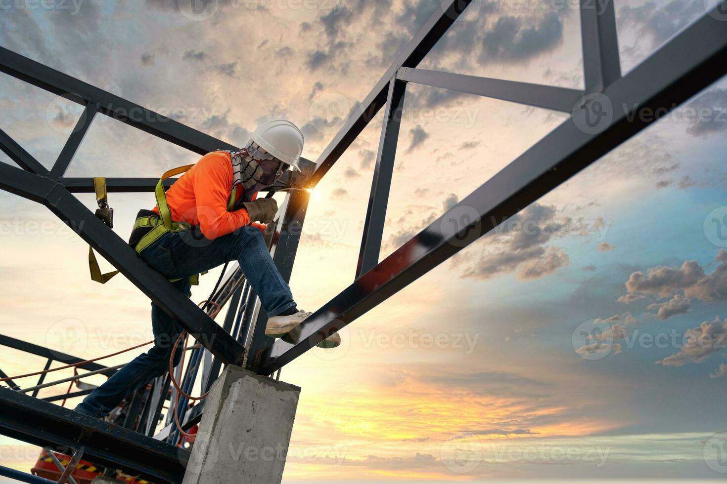 A Steel roof truss welders are working on the roof structure with safety devices to prevent fall safety at the construction site. photo