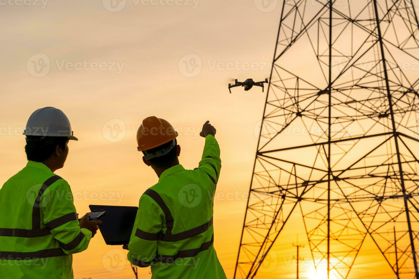 ingenieros ubicación ayuda técnico utilizar zumbido a mosca inspecciones a el eléctrico poder estación a ver el planificación trabajo por productor electricidad alto voltaje eléctrico transmisión torre a puesta de sol foto