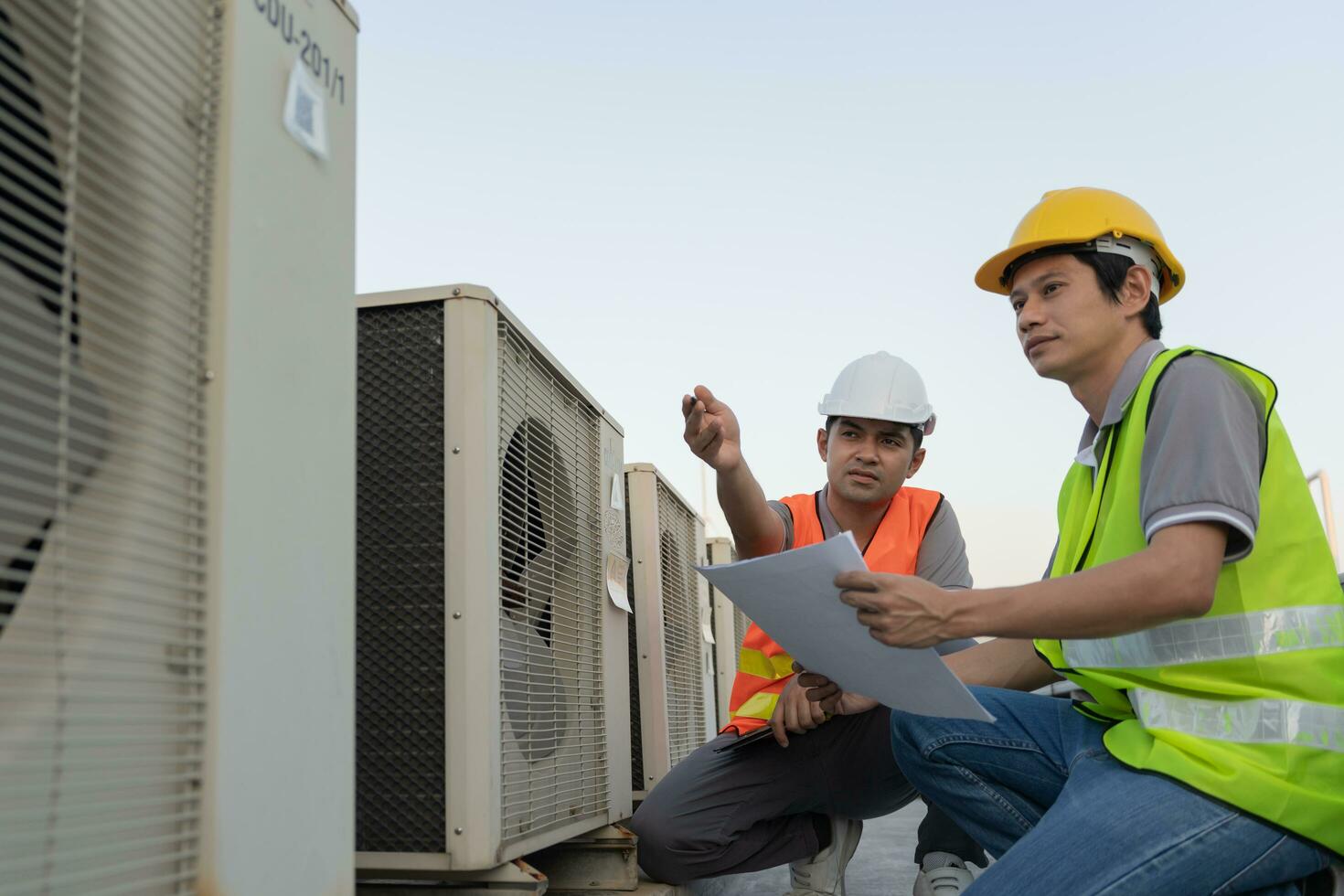 Engineers use blueprint check air condition systems on site. Contractor and inspector inspection compressor during project. maintenance team check quality assurance. Audit, inspect, quality control. photo